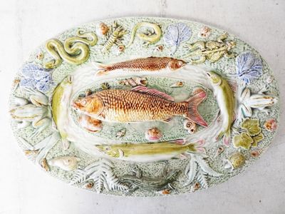 a plate with two fish on it and a snake on the plate