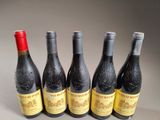 four bottles of wine are lined up on a table