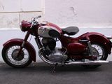 a red motorcycle parked in front of a white wall