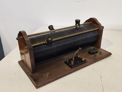 une locomotive à vapeur d'époque posée sur un socle en bois, sur une surface blanche