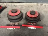 two red and black dumbs sitting on top of a cement floor