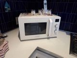 un micro-ondes blanc posé sur un plan de travail dans une cuisine