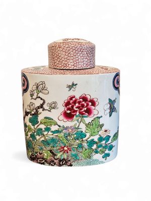 a vase with a lid that has flowers and birds on it