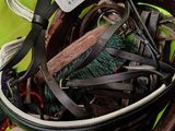 a bucket full of belts and other items on a table