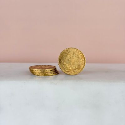a stack of gold coins sitting on top of a white table