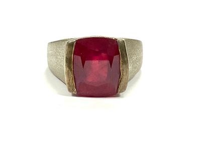 a close up of a ring with a red stone in it