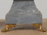 a marble clock on a stand on a table