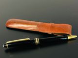 un stylo et un étui en cuir posés sur une table