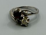 une bague en argent ornée d'un grenat et d'un motif floral