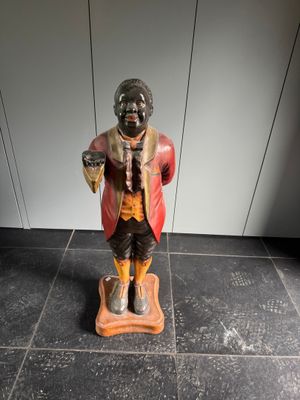 une figurine représentant un homme debout sur une balance