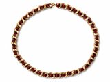 a close up of a gold and red necklace on a white background