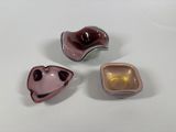 three different colored bowls sitting on top of a white surface