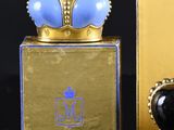 une boîte dorée ornée d'une couronne bleue, à côté d'une boîte dorée ornée d'une couronne bleue