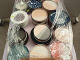 many jars of paint on a table covered in plastic wrap