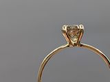 a close up of a person ' s hand holding a diamond ring
