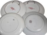 four white plates with red writing on them sitting next to each other