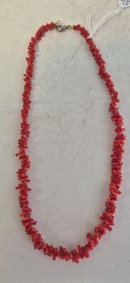 a red coral necklace with silver clasp on a white background
