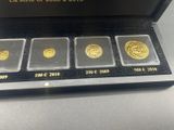 three gold coins in a black box on a table