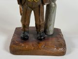 a figurine of a man and a woman standing on a rock