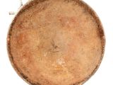 a large brown bowl with a handle on a white surface
