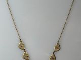 a gold necklace with five triangulars on a chain