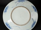 blue and white plate on black background with blue flowers