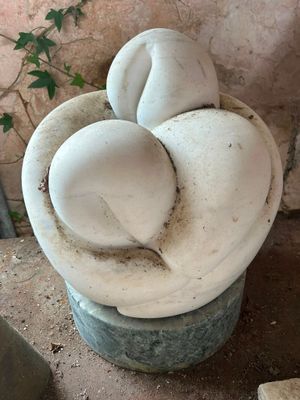 a statue of a flower in a bucket on the ground