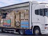 un camion avec une remorque remplie de cartons à l'arrière