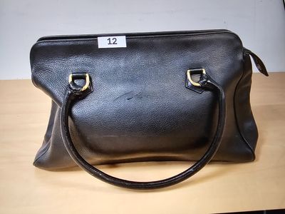 black leather handbag sitting on a table with a price tag on it