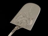 a silver spoon with a design on it on a black background