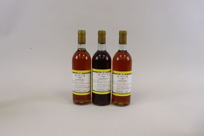 trois bouteilles de vin posées les unes à côté des autres sur une surface blanche