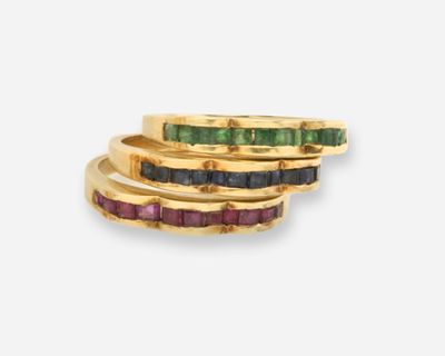 un gros plan sur trois bagues en or ornées de pierres de différentes couleurs