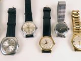 several different types of watches are lined up on a white surface