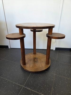 une petite table sur laquelle sont posés trois tabourets