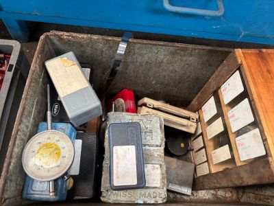 tout un tas d'outils dans une boîte métallique posée par terre