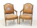 paire de fauteuils anciens en cuir avec structure et accoudoirs en bois