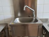 a stainless steel sink in the corner of a kitchen