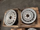 some silver rims are sitting in a box on the floor
