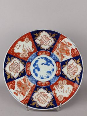une image représentant une assiette décorative ornée d'un motif bleu et rouge
