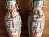 two vases that are sitting on a brown surface