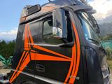 a black and orange semi truck parked in a lot