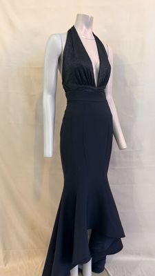 a woman in a black dress is standing next to a mannequin