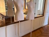 trois mannequins posés sur un socle devant un miroir