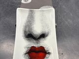 une assiette sur laquelle est représenté le visage d'une femme