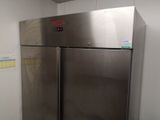 a stainless steel refrigerator in the corner of a room