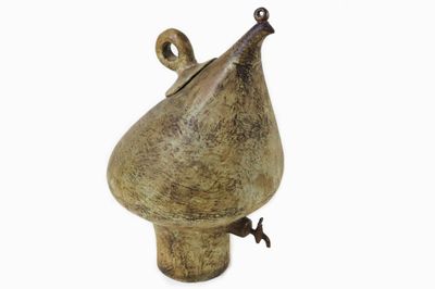 un vase marron orné d'un oiseau sur fond blanc
