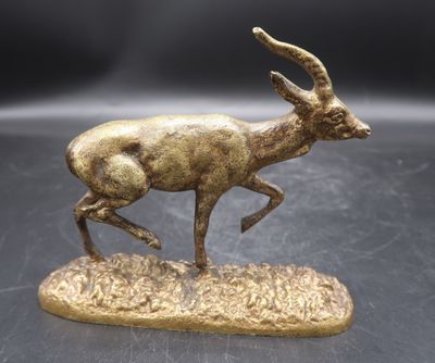 statue en bronze représentant une gazelle courant sur un rocher posé sur un fond noir