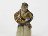 a small figurine of a man sitting on a stool