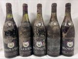 six bouteilles de vin sont alignées sur une table