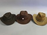 three different hats are lined up on a white surface